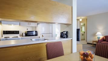 Cocina compacta con microondas, estufa, pileta y cafetera. Cuenta con un comedor con mesa y sillas.