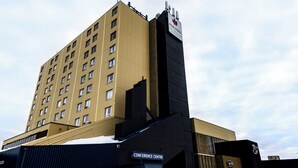 A multi-story building with a sign for "Paradise" and "Conference Centre" on the lower part. - Paradise Inn & Conference Centre (Grande Prairie)