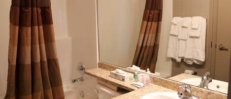 A bathroom with a bathtub, a sink, a mirror, and a towel rack.