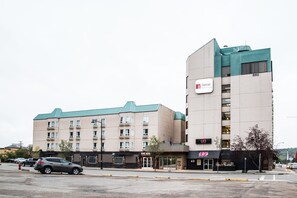 A hotel with a modern design, featuring a prominent sign for 'Nomad Hotel & Suites' and 'The Keg' restaurant. - Nomad Hotel and Suites (Fort McMurray)