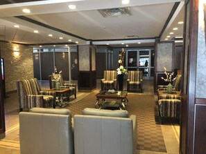 A spacious lobby with leather sofas, patterned armchairs, and a central coffee table. - Nomad Hotel and Suites (Fort McMurray)