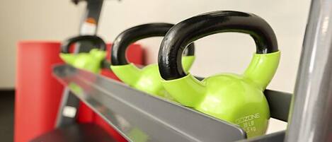 Un soporte para equipamiento de gimnasio con pesas y mancuernas.