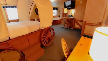 A room with a bed, a desk, a chair, and a television.