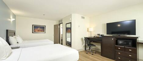 Een hotelkamer met twee bedden, een bureau, een televisie en een magnetron.