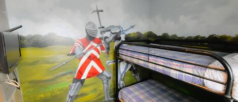 A room with bunk beds, a mural of a knight on horseback, and a television on the left.