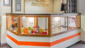 Un salon de dégustation de glaces Howard Johnson, avec un comptoir en bois et une vitrine réfrigérée.