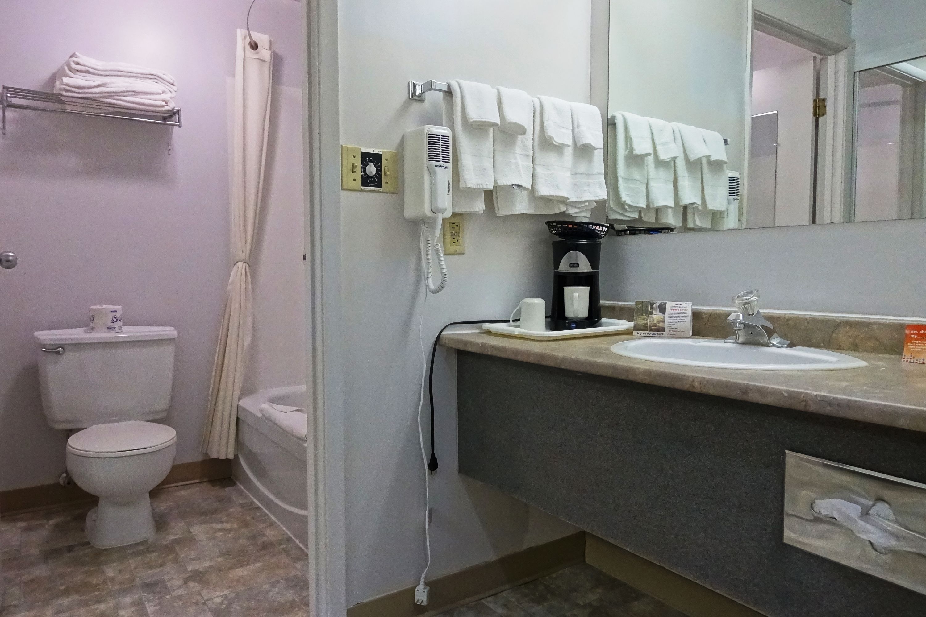 Un baño con inodoro, lavamanos, espejo y ducha.