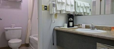Un baño con inodoro, lavamanos, espejo y ducha.