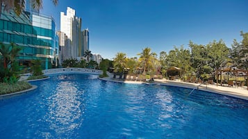 Una piscina al aire libre, sombrillas, tumbonas