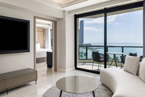 A modern hotel room with a large balcony, a flat-screen TV, a sofa, and a dining table. - InterContinental Miramar Panama by IHG (Panama City)