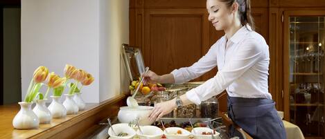 A buffet setup with various food items and utensils.