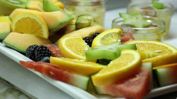 Een schaal met een verscheidenheid aan fruit, zoals meloen, watermeloen en stukjes citrus.