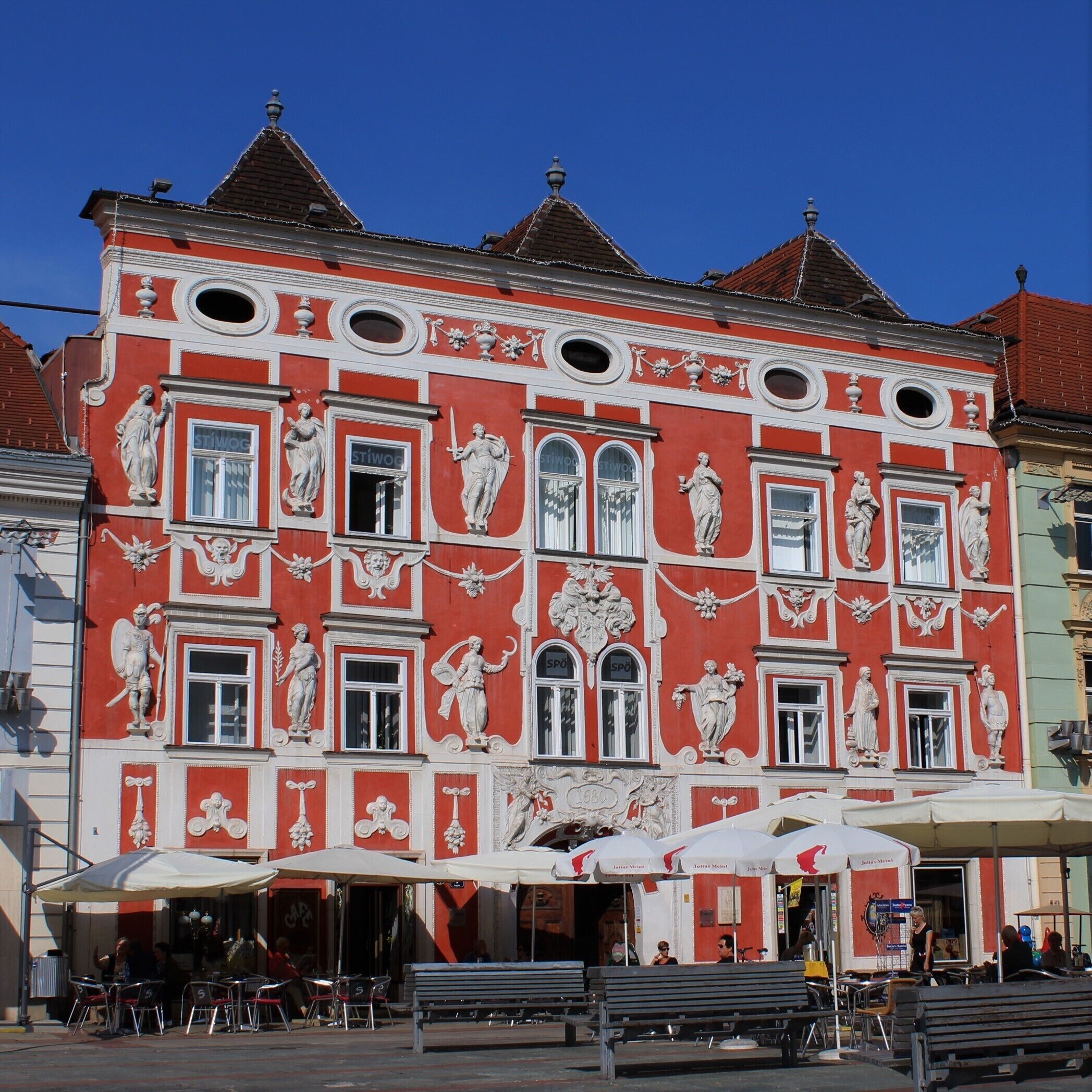 A red building with white decorative elements and multiple windows.