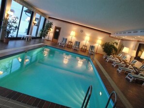 Una piscina al aire libre, tumbonas