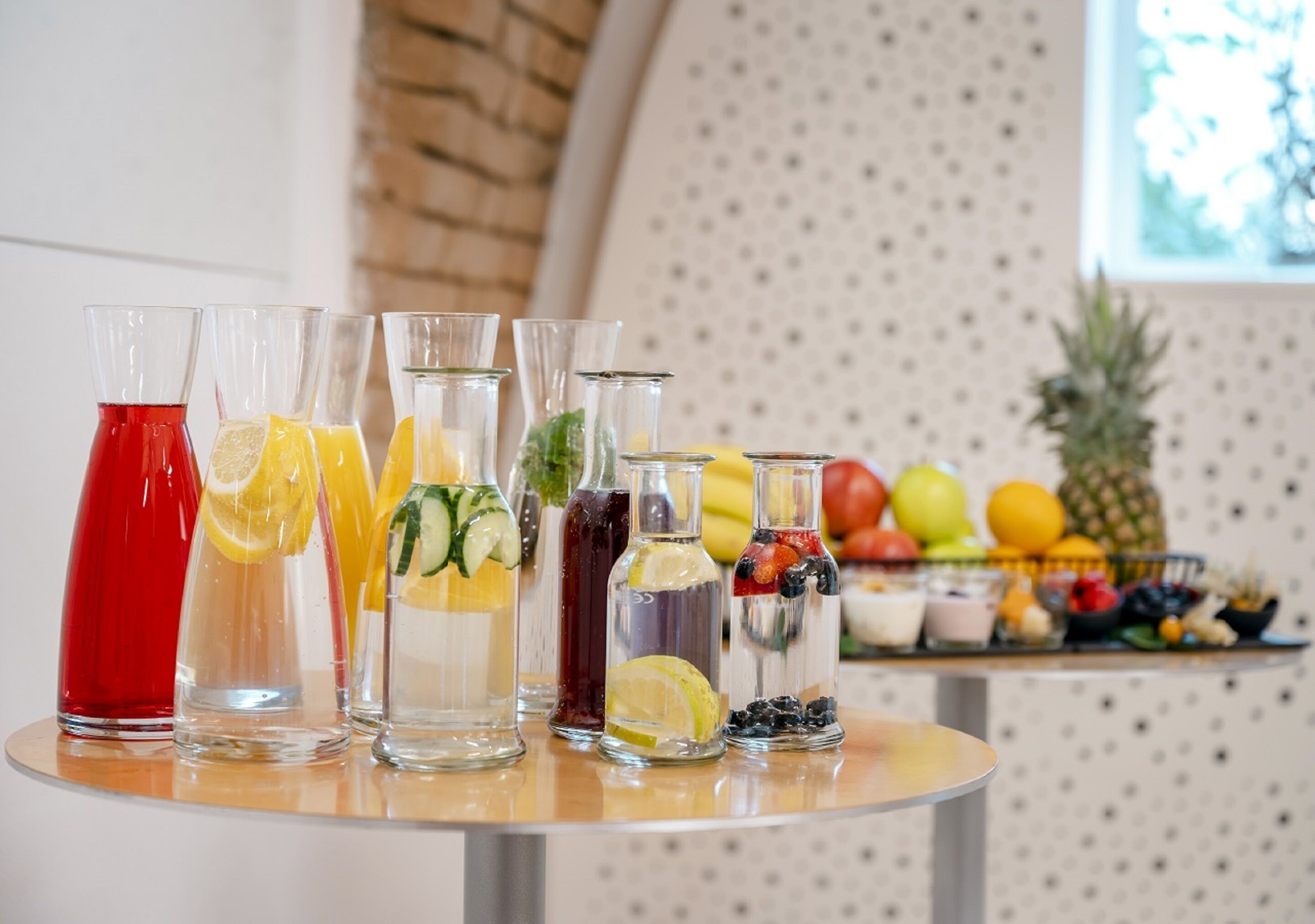 Una mesa con diversas bebidas y frutas.