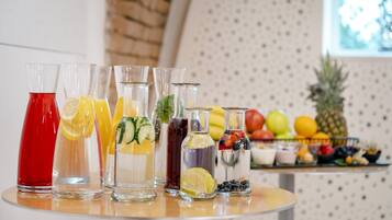 Una mesa con diversas bebidas y frutas.