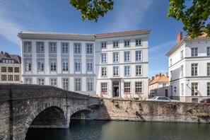 Eine historische Steinbrücke über einen Kanal mit klassischen weißen Gebäuden an beiden Seiten.