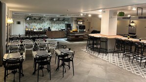 A modern kitchen with a central island, bar seating, and a dining area with tables and chairs. - Floris Arlequin Grand Place (Brussels)