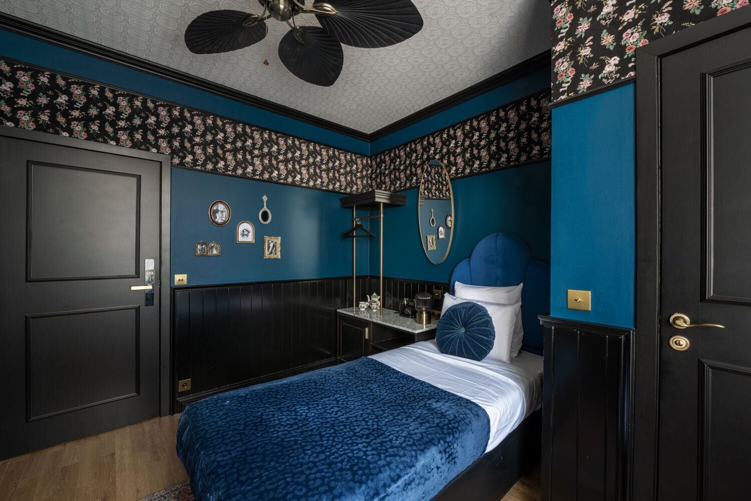 A bedroom with a bed, a dresser, a mirror, and a ceiling fan.