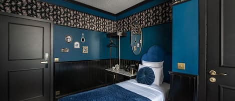 A bedroom with a bed, a dresser, a mirror, and a ceiling fan.