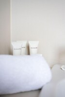 A neatly arranged set of Perricone MD skincare products on a white surface, likely in a hotel room.