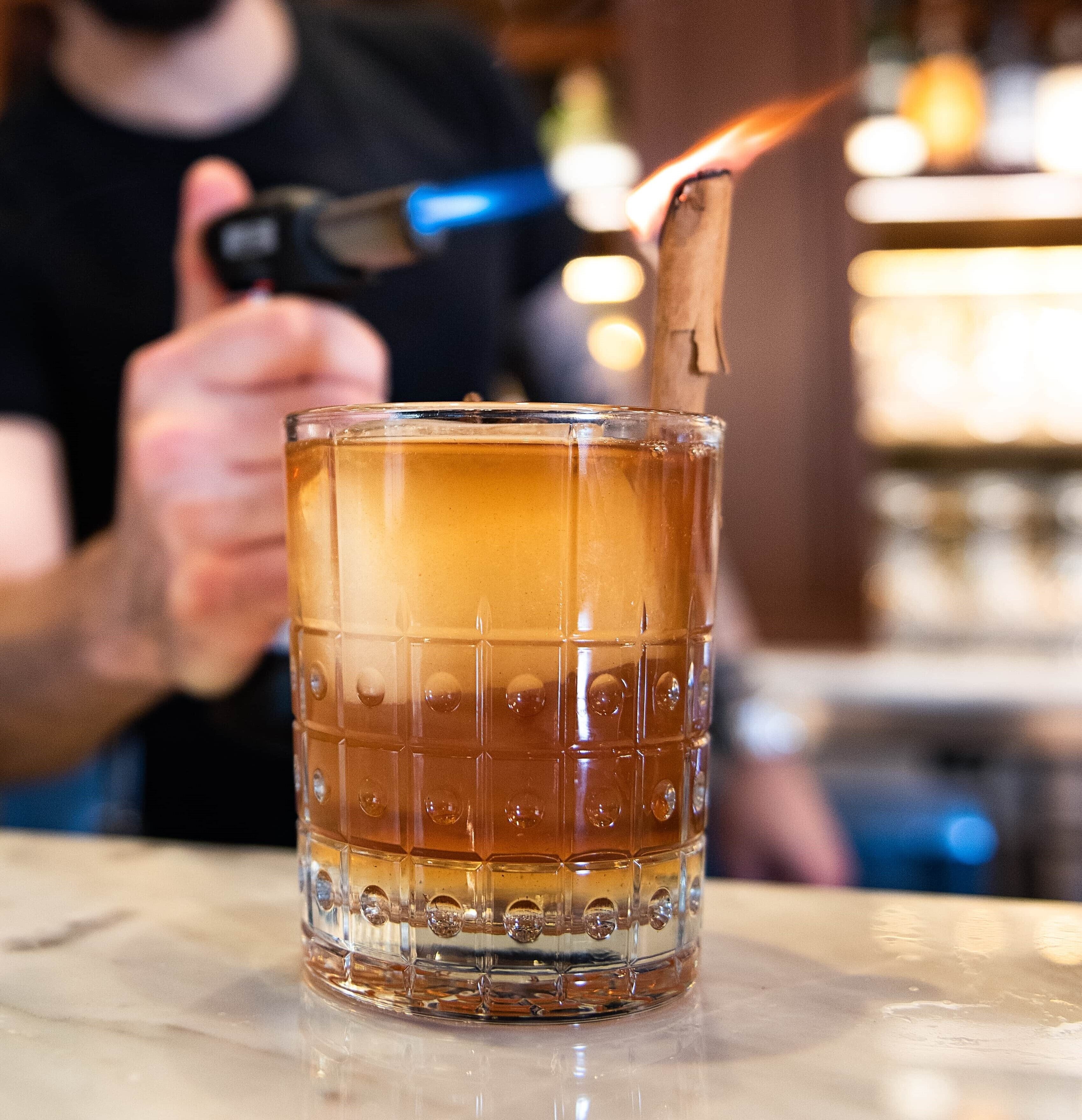 Een glas met een geribbelde textuur en een aangestoken lucifer erin.