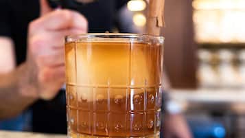 A glass with a textured pattern and a lit matchstick inserted into it.