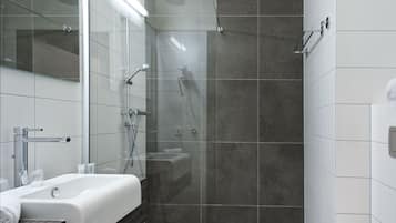 A modern bathroom with a glass-enclosed shower, a white sink, and a mirror.