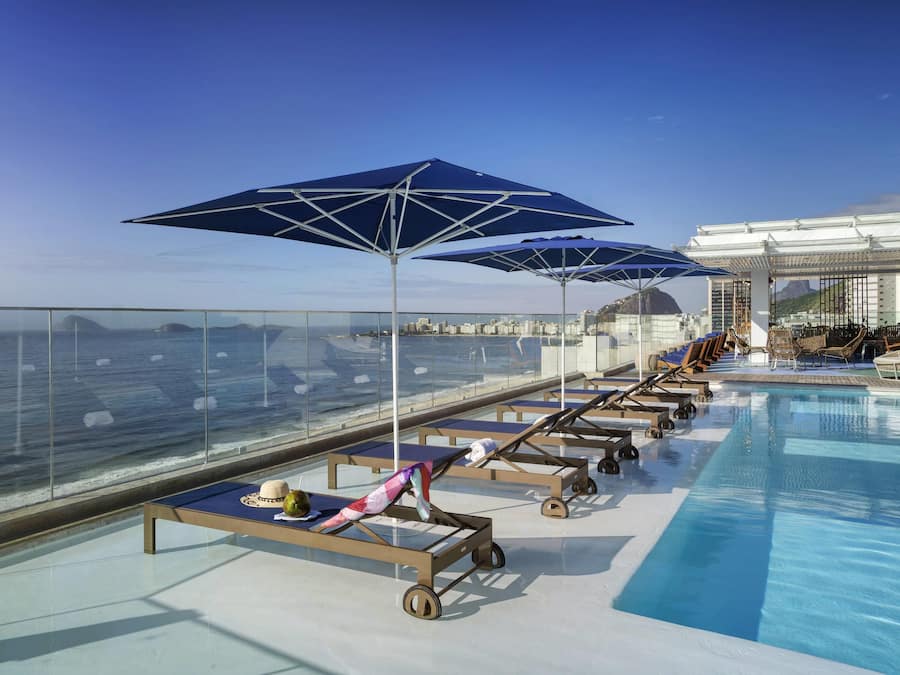 Una piscina al aire libre, sillones reclinables de piscina