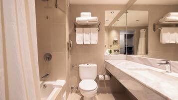 Une salle de bain moderne avec une baignoire, des toilettes et un grand miroir.