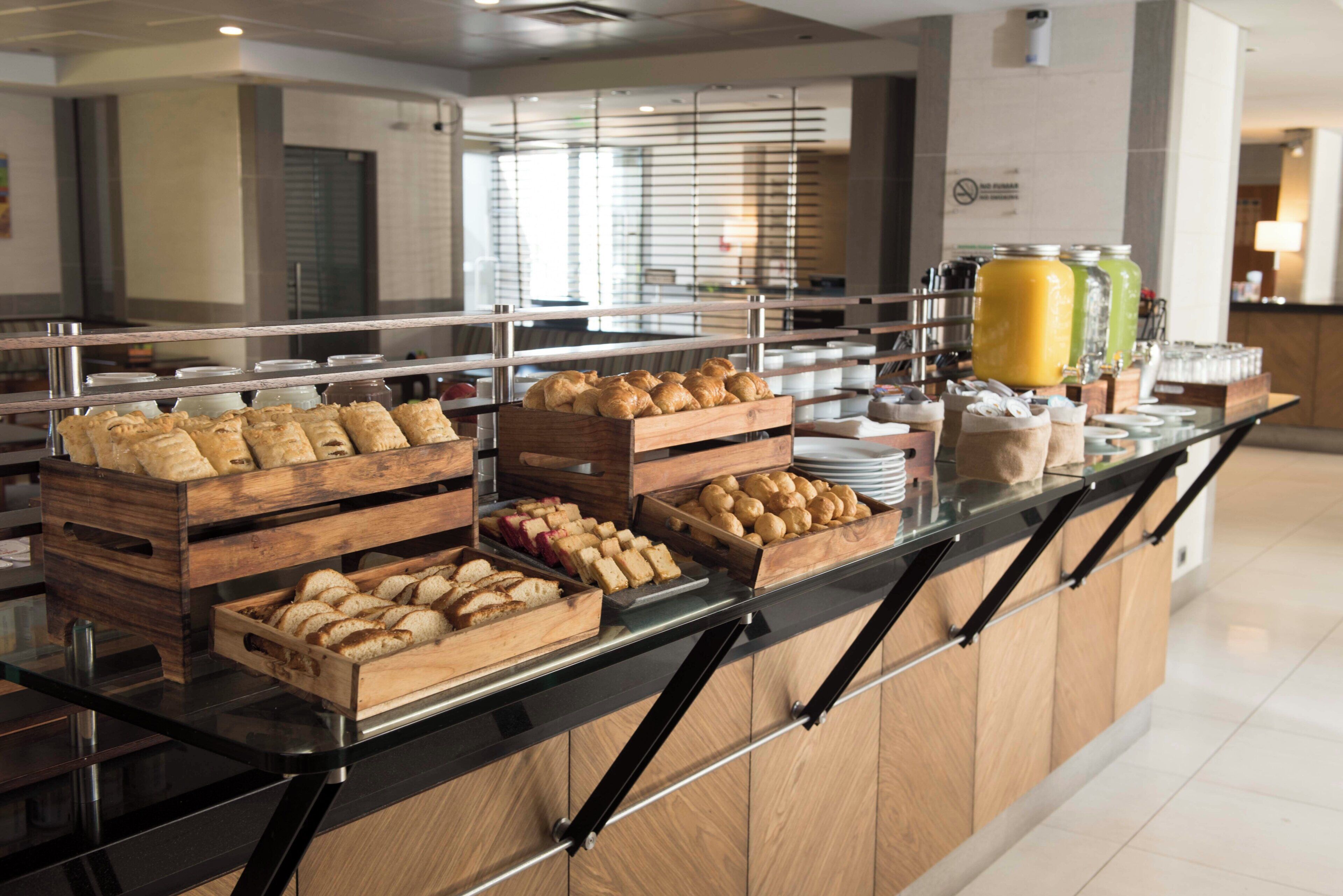 Un comptoir de buffet proposant une variété de produits de boulangerie et de boissons.