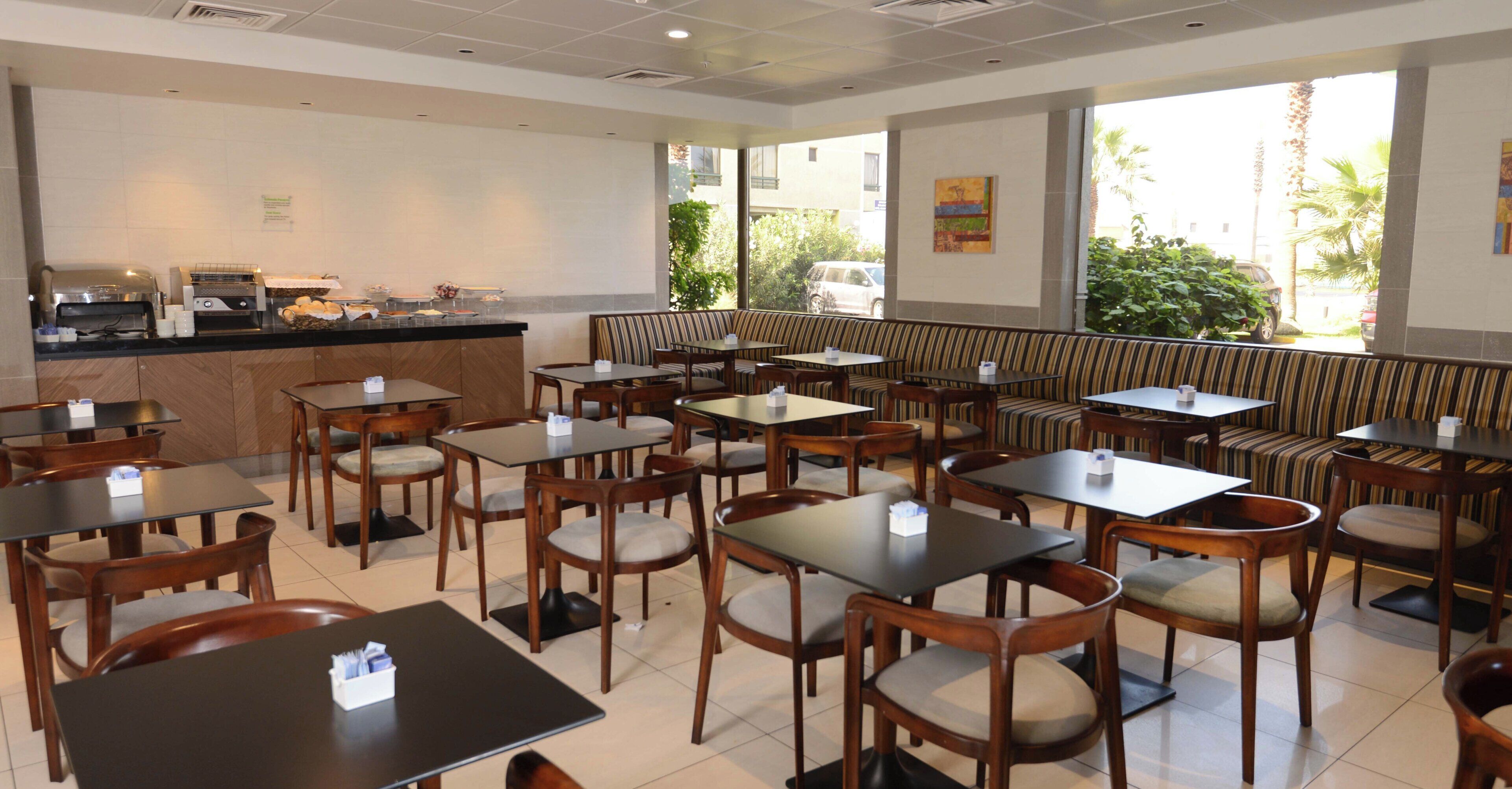 A restaurant with a counter, tables, and booths.