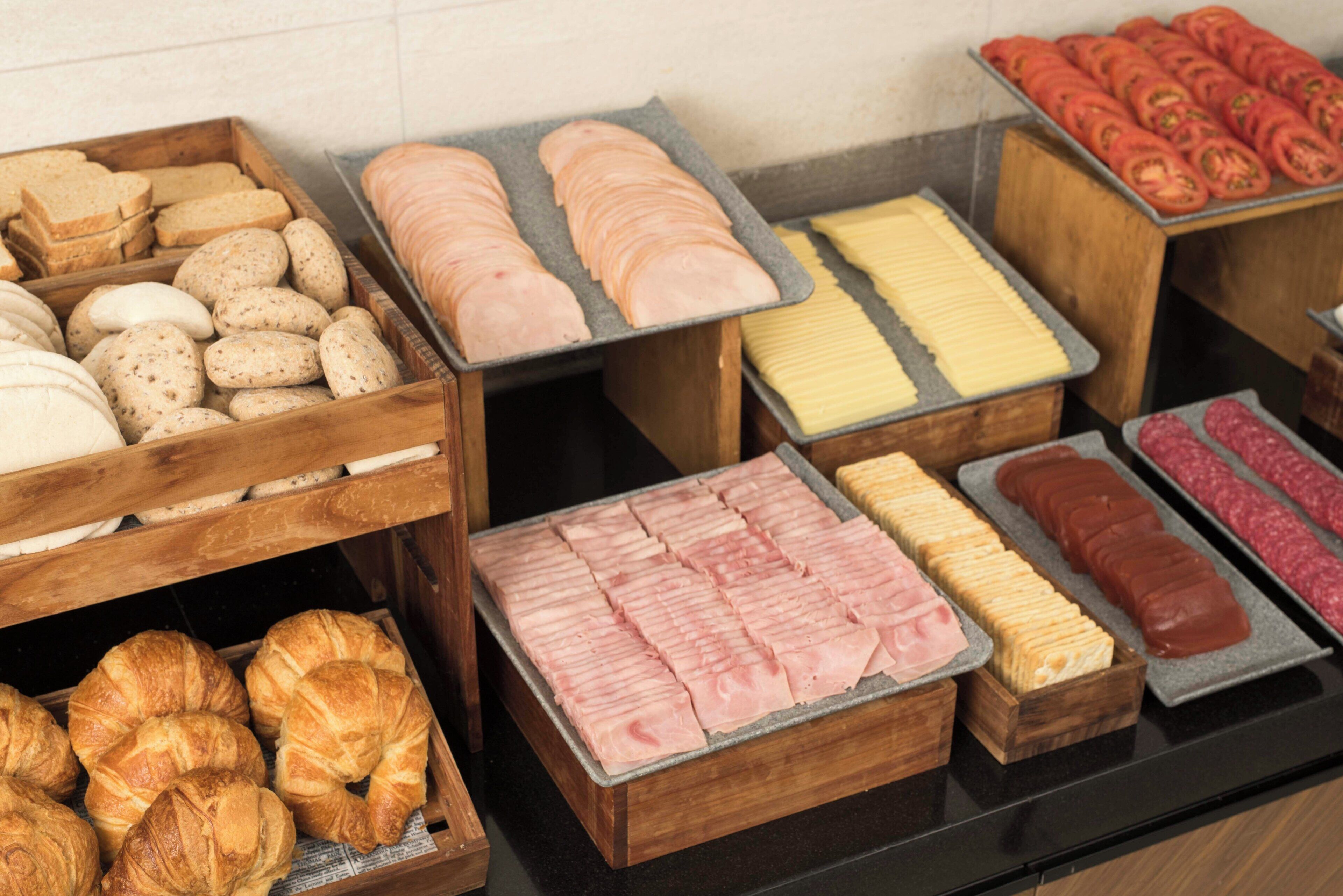Diversos alimentos presentados en bandejas de madera sobre una encimera.