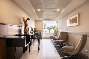 A reception area with a counter, chairs, a vase with dried plants, and a framed picture on the wall. - Holiday Inn Express Iquique by IHG (Iquique)