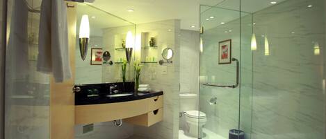 A modern bathroom with a glass shower enclosure, a large mirror, and a bathtub.