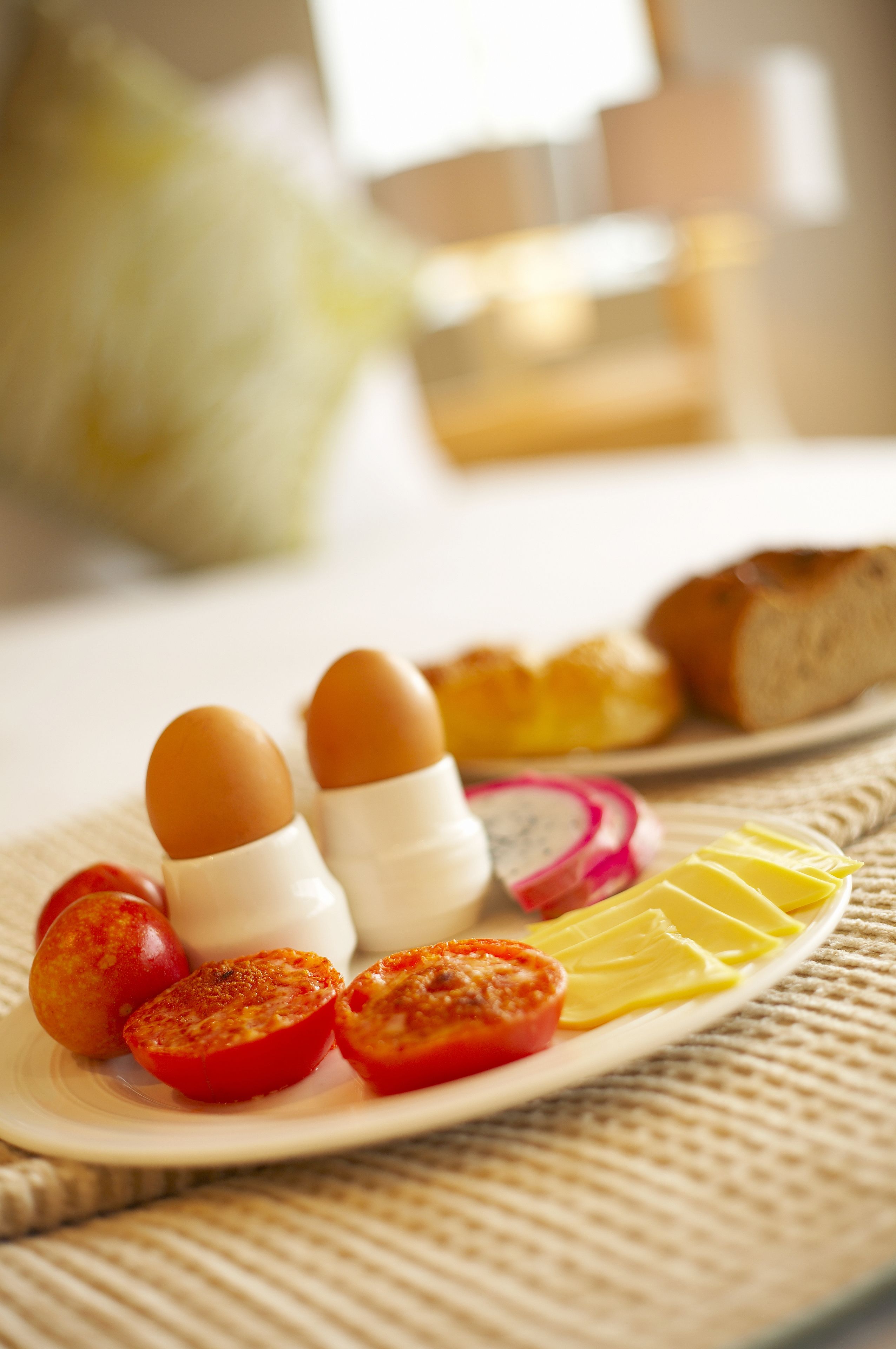 A plate with eggs, tomatoes, radishes, and cheese.