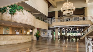 A spacious lobby with a checkered floor, a reception desk, a chandelier, and a staircase leading to an upper level. - Las Americas Casa de Playa (Cartagena)