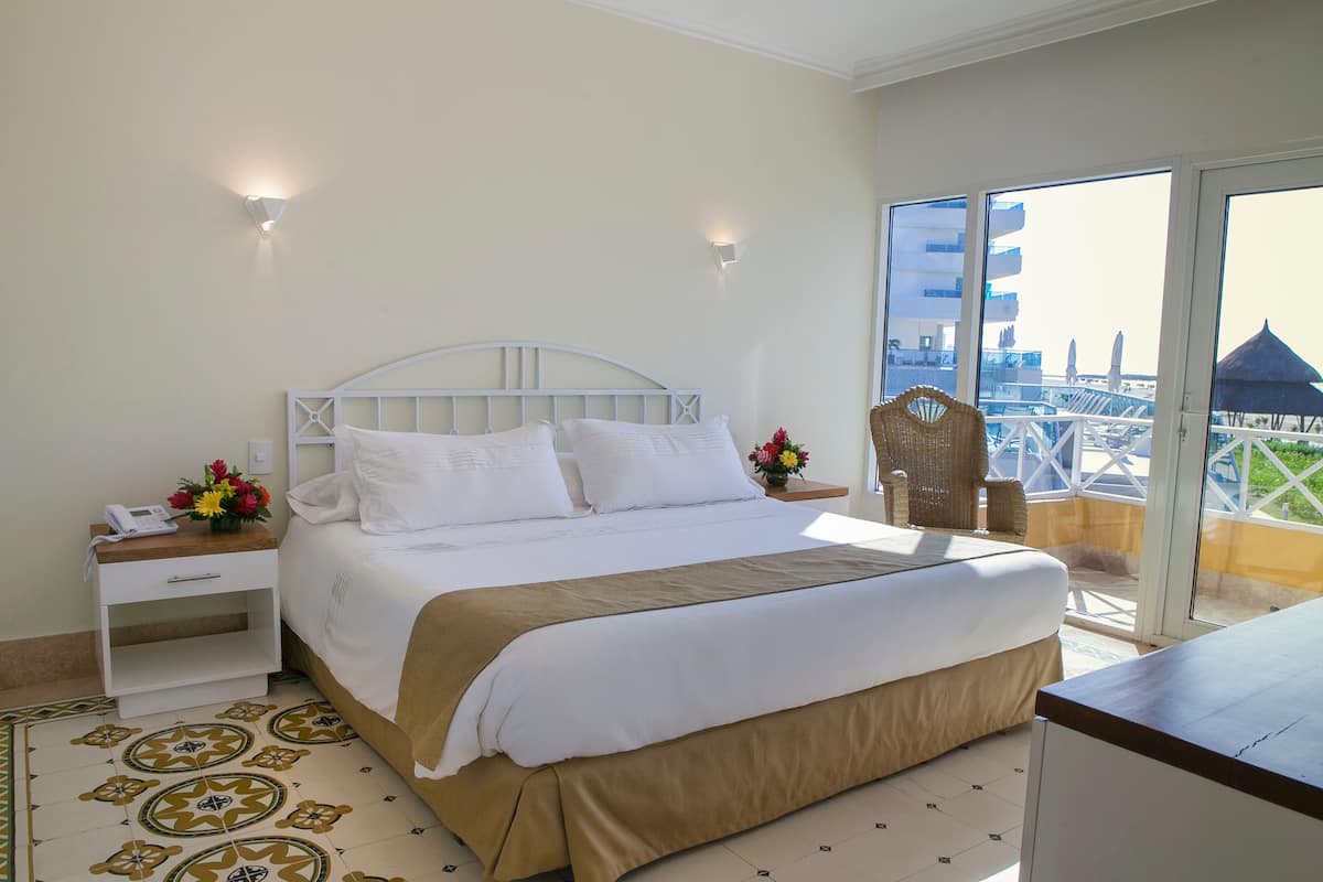 A hotel room with a bed, bedside table, and a view of the city.