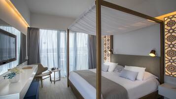 A modern hotel room with a large bed, a desk, and a chair.