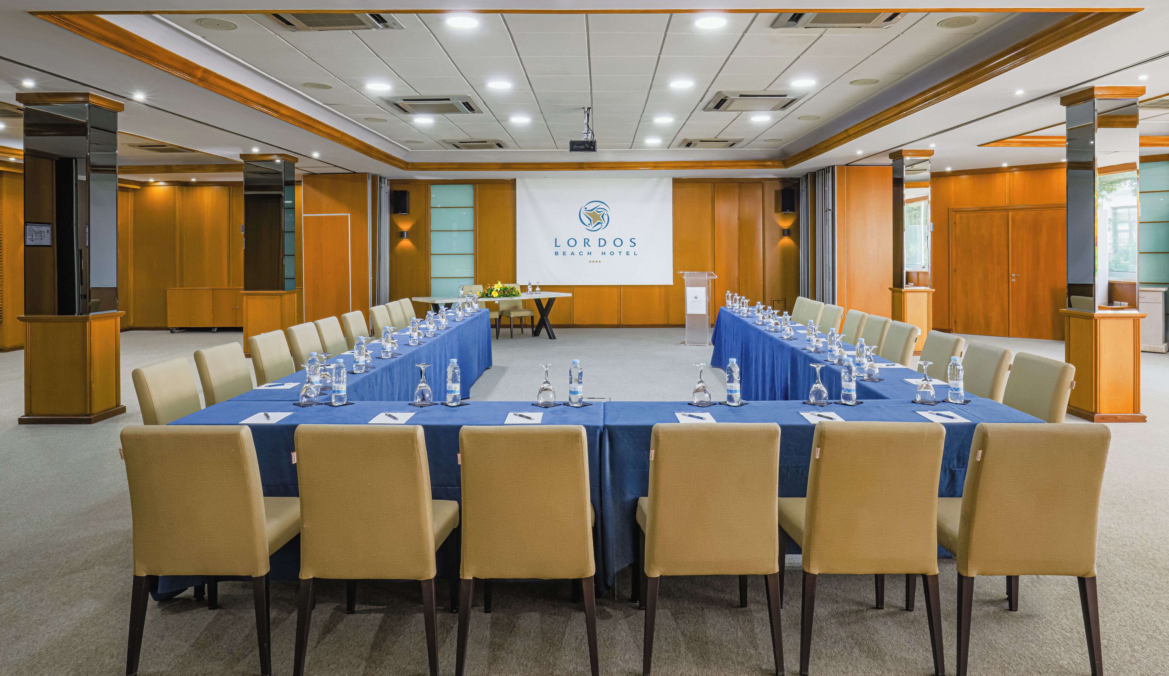 A conference room with a long table, chairs, and a podium.