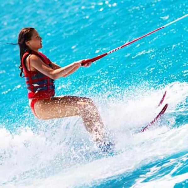 A person water skiing on a clear blue water body.