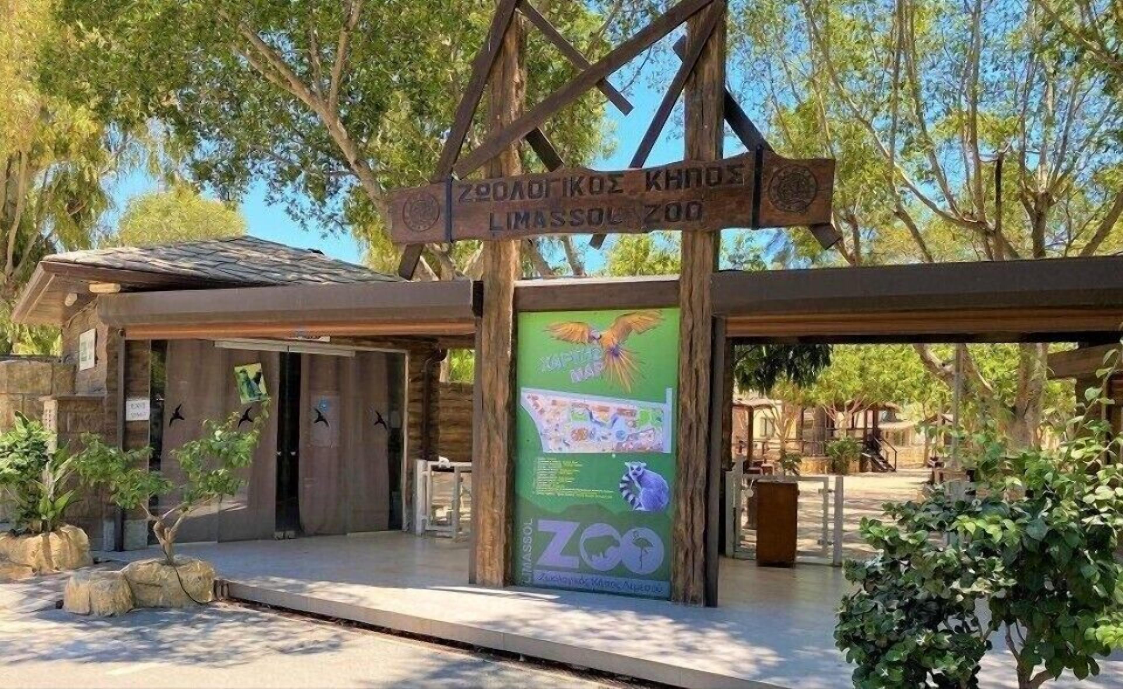 A wooden structure with a sign for Limassol Zoo, featuring a map and animal illustrations.