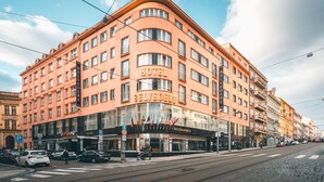 A multi-story hotel with a prominent "HOTEL" sign, a restaurant, and a parking area. - Hotel Belvedere (Prague)