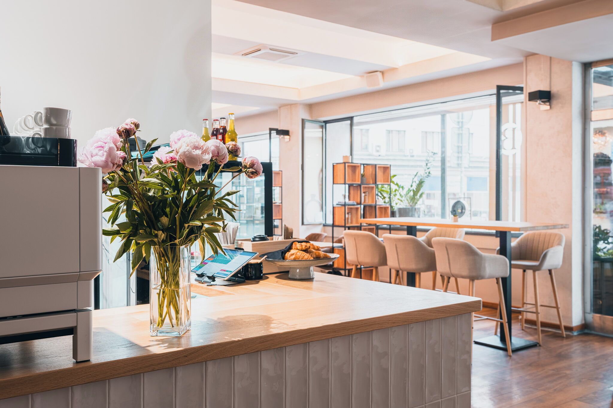Una cocina moderna con encimera de madera, un florero con flores y un comedor con sillas y una mesa.