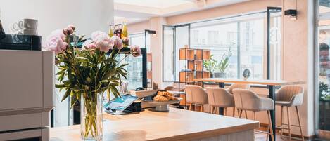 Una cocina moderna con encimera de madera, un florero con flores y un comedor con sillas y una mesa.