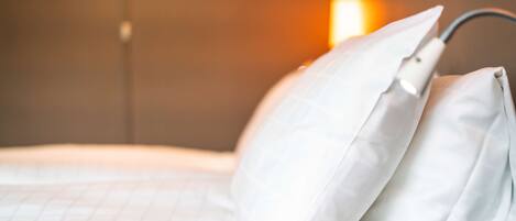 A neatly made bed with white bedding and a headboard.