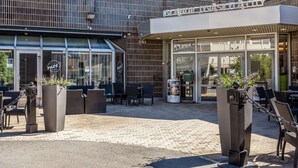 A modern building with a glass entrance and outdoor seating area. - Scandic Jyväskylä City (Jyväskylä)