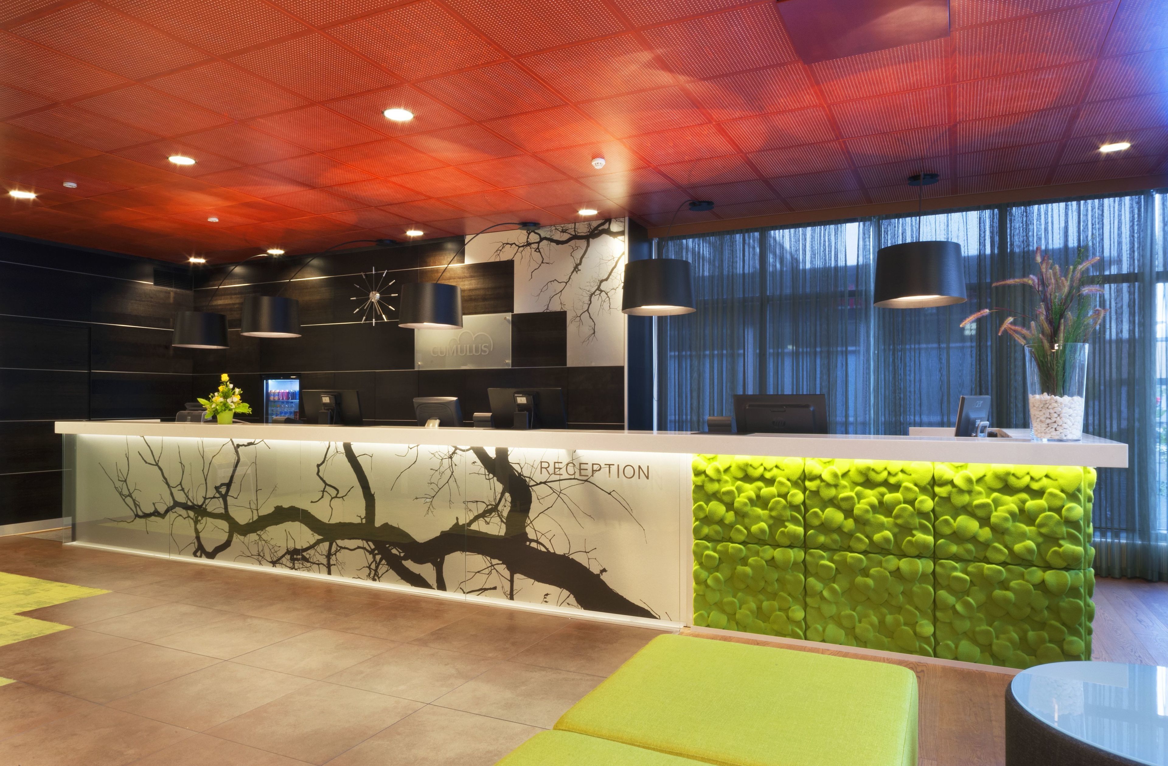 A reception area with a modern design, featuring a reception desk, seating area, and large windows.