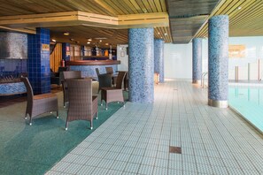 A pool area with seating and a bar. - Scandic Pohjanhovi (Rovaniemi)