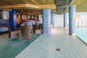 Uma área de piscina com assentos e bar.